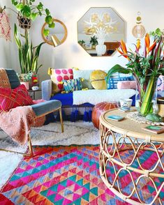 a living room filled with lots of colorful furniture and plants on top of the tables