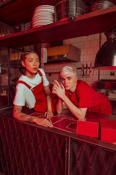 two people standing behind a counter in a restaurant