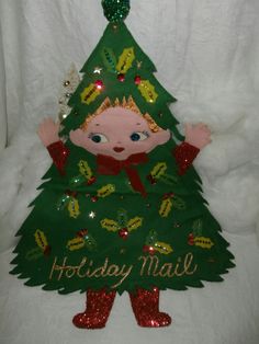 a green christmas tree with a child's face on it and the words holiday mail written in gold