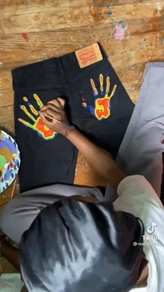 a person sitting at a table making handprints