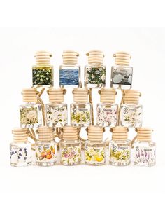 an assortment of glass jars with flowers and plants in them, all stacked on top of each other