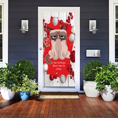 a door with an image of a cat on it and some potted plants next to it