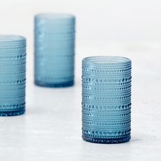 three blue glass cups sitting next to each other