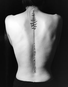 the back of a woman's upper back tattoo