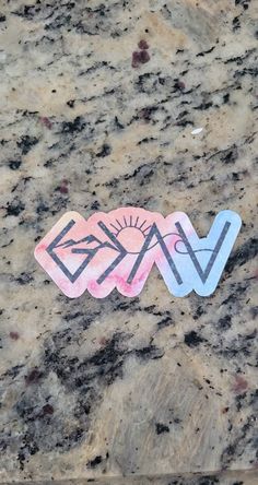 two stickers that are on top of a marble surface with the word kiss written in pink and blue