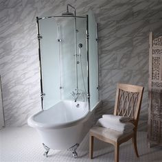 a white bath tub sitting next to a wooden chair