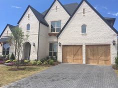 a large white brick house with two garages