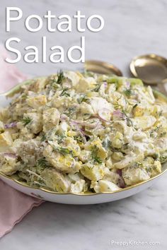 potato salad in a bowl with spoons on the side