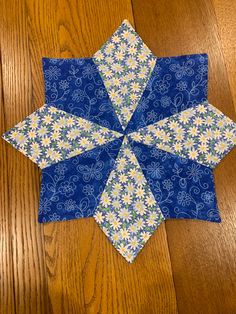 a blue and white quilted star on a wooden floor with wood floors in the background