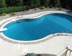 an above ground swimming pool surrounded by landscaping