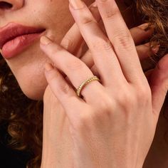 a close up of a person wearing a ring and holding her hand near her face