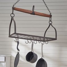 pots and pans hanging from hooks on a wall