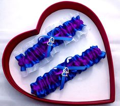 two purple and blue garters in a heart shaped box