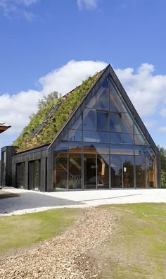 a building with a green roof and glass windows