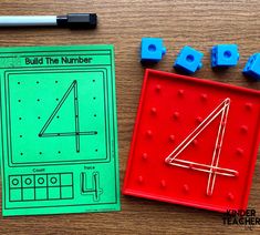 a wooden table topped with blue and red toys next to a green sheet that says build the number