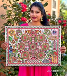 a woman is holding up a colorful painting