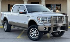 a silver truck parked in front of a building