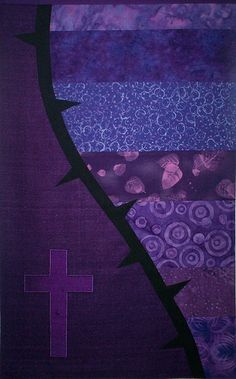 the cross is in front of an abstract painting with purple and blue colors on it