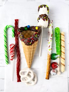 an ice cream sundae with candy canes, pretzels and marshmallows