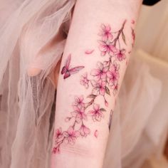 a woman's arm with pink flowers on it