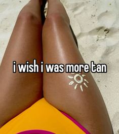 a woman laying on top of a sandy beach next to the words i wish i was more tan