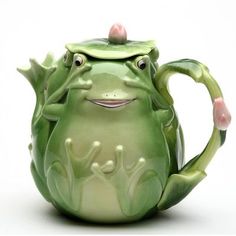 a green teapot with a frog face on it