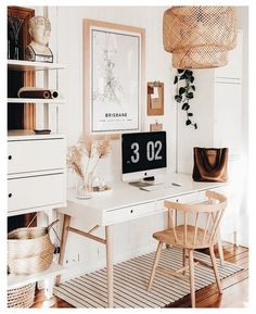 a desk with a computer on top of it next to a chair and potted plant