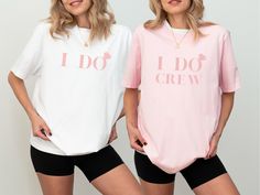 two women standing next to each other wearing t - shirts that say i do crew