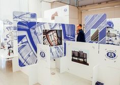 a man is walking through an exhibit with blue and white designs