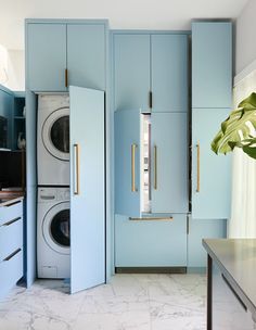 a washer and dryer in a room with blue cabinets