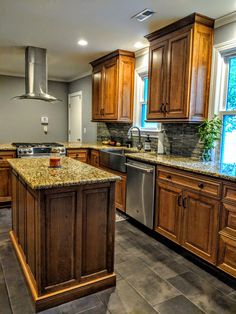 a large kitchen with granite counter tops and wooden cabinets, along with stainless steel appliances