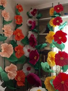 paper flowers are hanging on the wall in front of a window with an instagramr