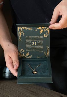 a person holding up a necklace in a box