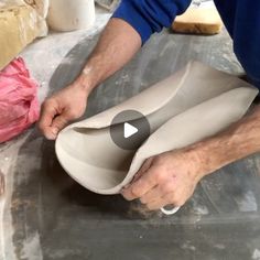 a man is working on an object in his pottery studio, making it look like he's about to make something out of clay