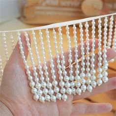 a hand is holding some white pearls