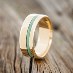 a wedding ring with two green stripes on it