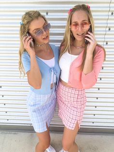 two girls standing next to each other talking on cell phones