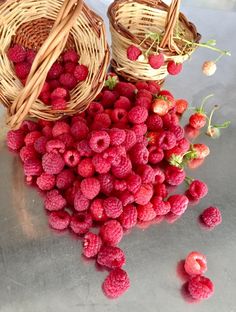 raspberries and straw baskets on a table