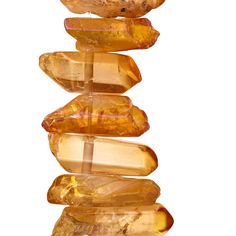 a group of yellow rocks stacked on top of each other in front of a white background