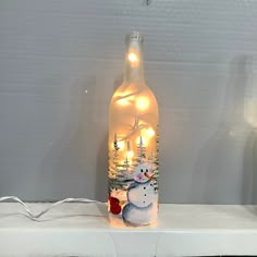 a lighted bottle with a snowman on it