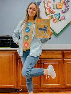 a girl holding up a sign with buttons on it