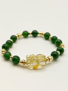 High Clarity Gold Rutilated Quartz engraved Pixiu with kiwi 🥝 green Antigorite crystal beads. Length of bracelet: 7.25 inches Size of Gold Rutile Pixiu : 18mm(L), 12.4mm(W), 10mm(H) Diameter of Green Antigorite: 8mm Please specify wrist length when making the order with the seller Gold Jade Beaded Bracelets For Spiritual Purposes, Spiritual Gold Jade Beaded Bracelets, Green Jade Crystal Bracelet For Meditation, Pixiu Bracelet, Gold Jade Crystal Bracelet, Spiritual Style, Rutilated Quartz, Kiwi, Diy Bracelets, Crystal Beads