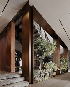 the interior of a modern house with trees and rocks in the foreground, along with stairs leading up to the second floor