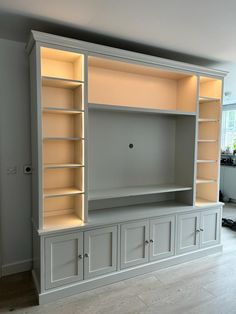 a large white entertainment center with built - in shelving units and lights on each shelf