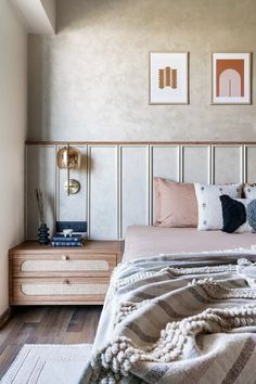 a bed sitting in a bedroom next to two framed pictures on the wall above it