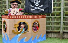 a man and two children in a cardboard pirate ship