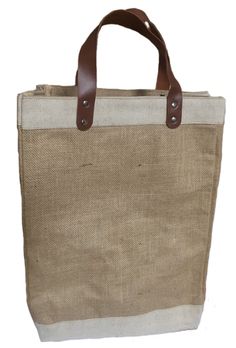 a large jute bag with leather handles and straps on the side, against a white background