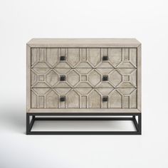 a white and black cabinet with geometric designs on the front, sitting against a wall