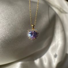 Add a touch of regal elegance to your jewelry collection with this Purple Royal Heart Necklace. The tiny violet halo pendant is made of non-tarnish 925 sterling silver, making it a durable and affordable choice for a love-themed gift. The purple color adds a touch of whimsy and femininity to any outfit, making it perfect for any occasion. Whether you're dressing up for a night out or just want to add a pop of color to your everyday look, this Purple Royal Heart Necklace is the perfect choice. Bu Formal Amethyst Jewelry For Valentine's Day, Purple Sterling Silver Heart Pendant Necklace, Purple Heart Necklace For Anniversary, Sterling Silver Purple Heart Pendant Necklace, Purple Heart Cut Sterling Silver Necklace, Purple Heart-cut Sterling Silver Necklace, Purple Sterling Silver Heart Cut Necklace, Elegant Round Gemstone Heart Necklace, Purple Heart Pendant Necklace For Anniversary