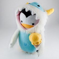 a stuffed animal that is wearing a blue and white outfit with horns on it's head